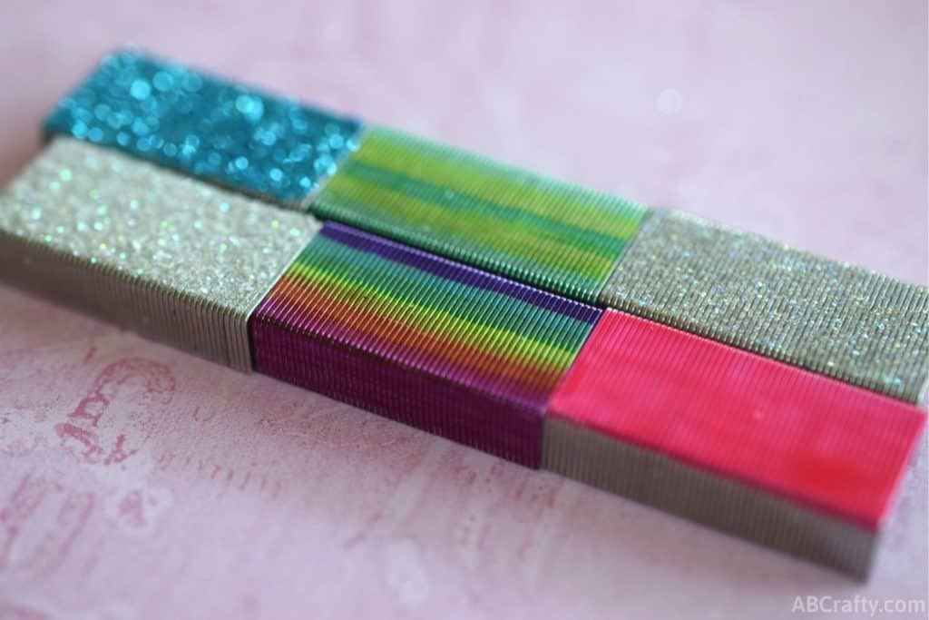 multi colored staples, including glitter blue staples, rainbow staples, green staples, and pink staples