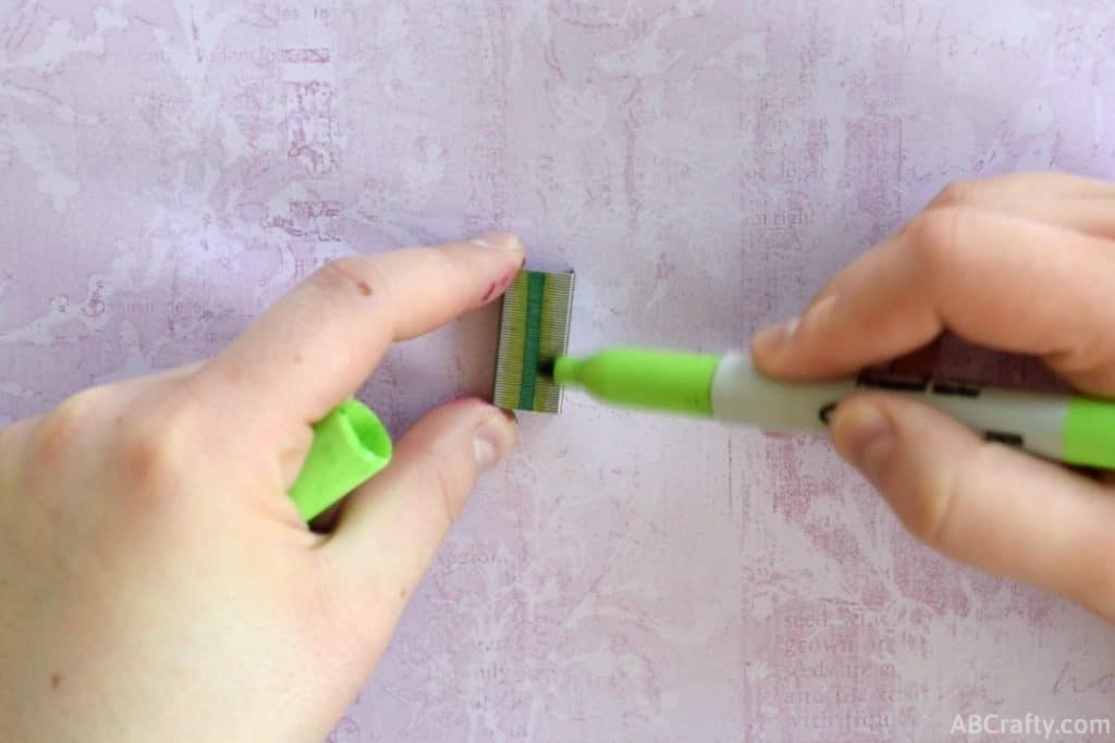 coloring staples with a light green sharpie next to a green stripe