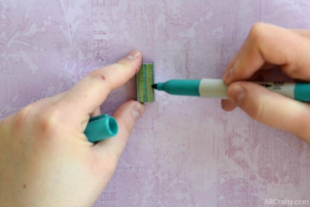 drawing a line onto staples with a dark green permanent marker