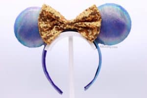finished disney world 50th anniversary ears that are blue and purple iridescent with a gold sequin bow