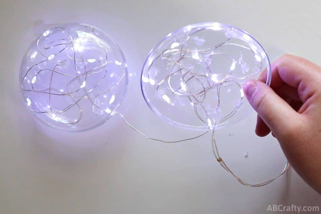 disc ornaments with fairy lights glued into them and lit up