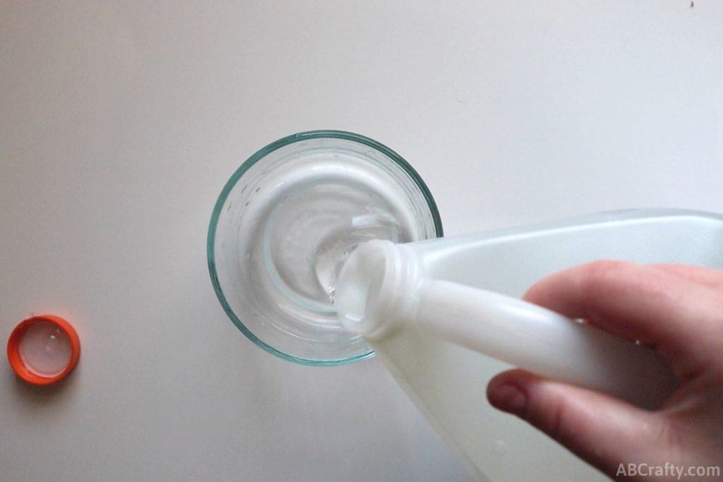 pouring clear glue into a glass bowl