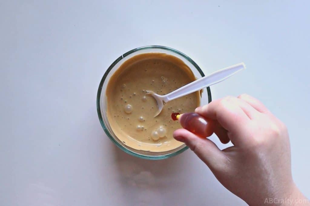 dropping yellow food coloring to a bowl with gold goo