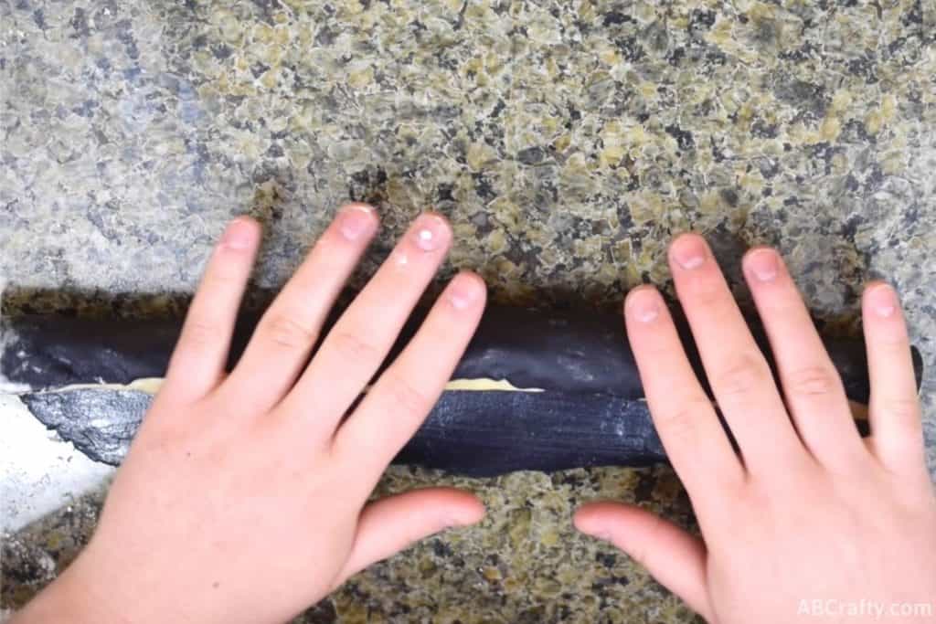 wrapping black rectangle of cookie dough around plain log