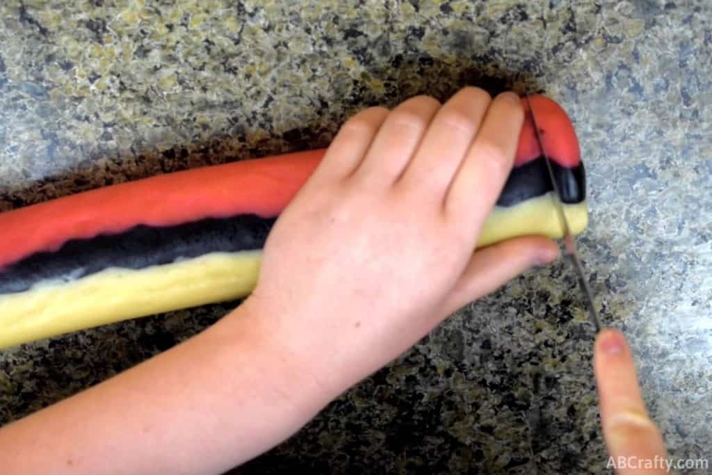 using a knife to cut off a small section of pokemon sugar cookie dough