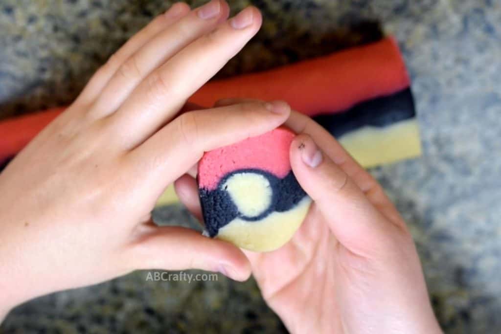 shaping pokemon cookie dough that's in the shape of a pokeball