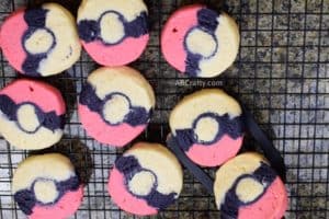 using spatula to put two pokemon cookies onto cooling rack with other pokemon sugar cookies