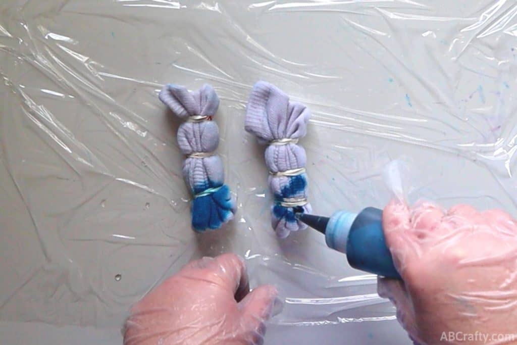 squeezing blue dye out of a plastic bottle onto