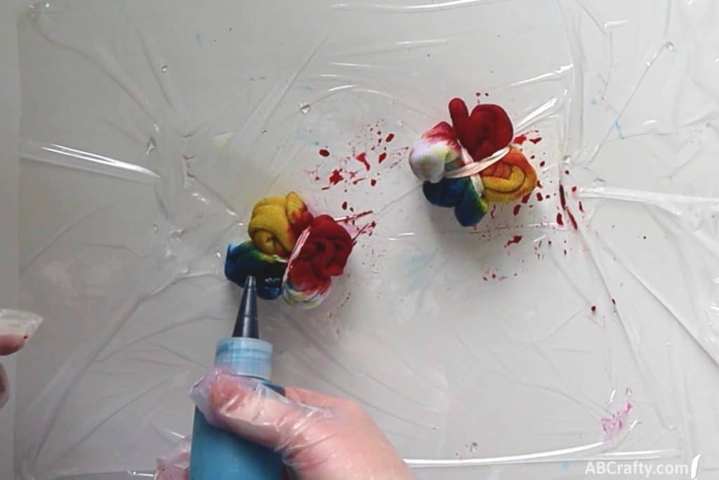 adding blue dye from a squeeze bottle next to yellow