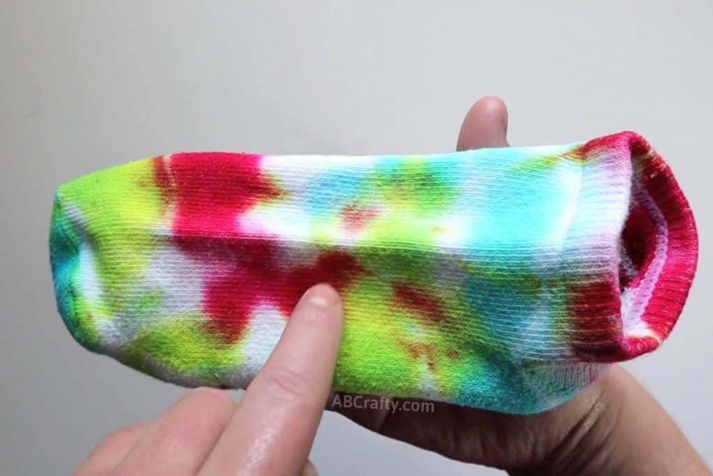 pointing at the middle of a spiral on a spiral tie dye sock