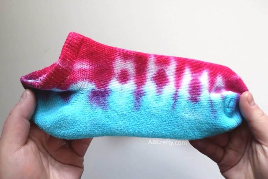 holding a blue and red tie dye sock