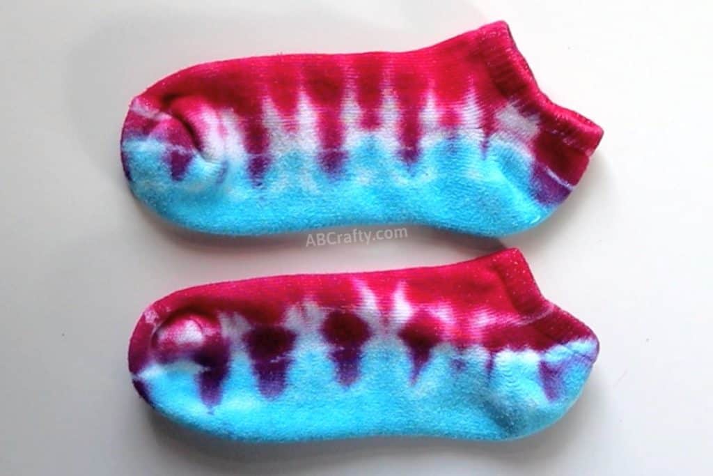 two blue and red tie dye socks with the blue on bottom and red on top