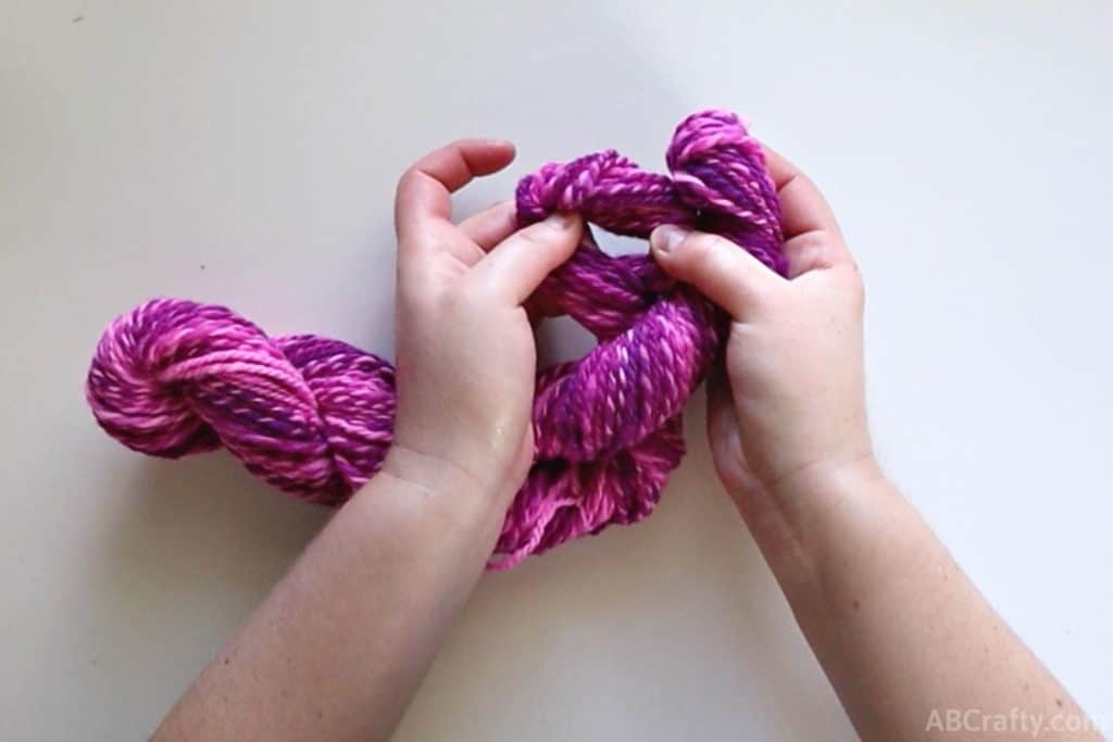 opening the end of yarn to show a hole