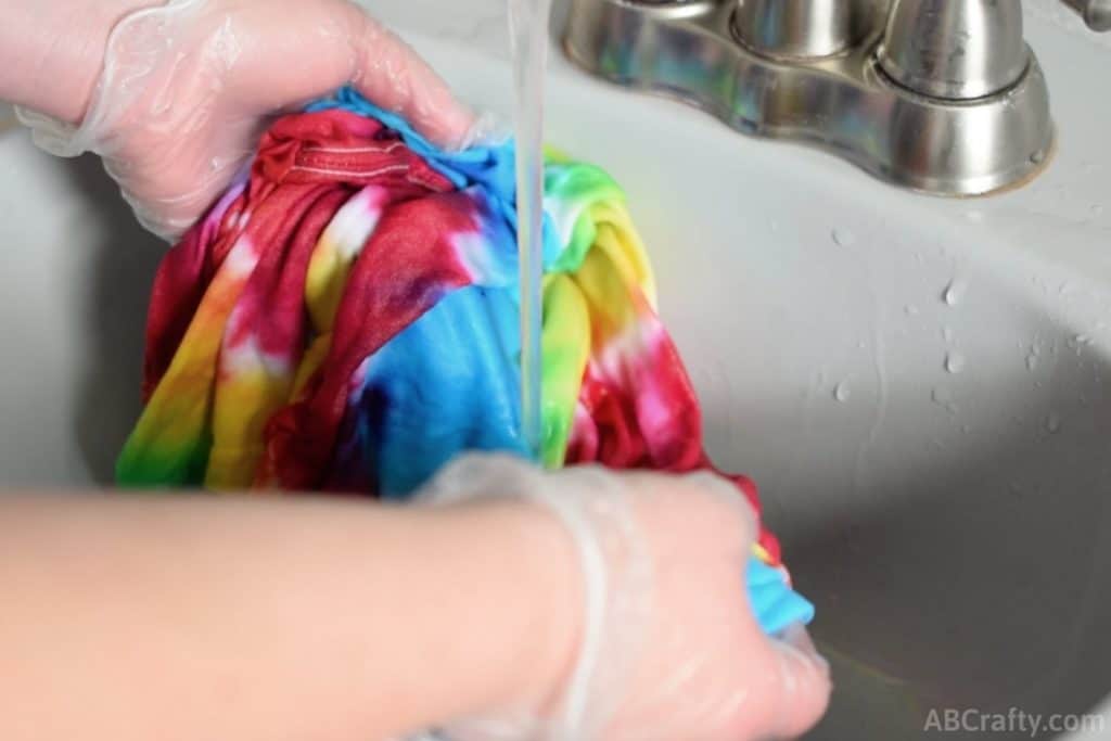 rinsing a tie dye shirt under the faucet