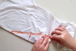 folding a white cotton shirt along the outline of the candy corn
