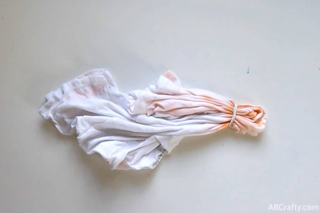 the white shirt folded and wrapped with a rubber band