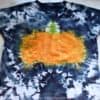 finished tie dye pumpkin shirt with a pumpkin in the middle and black tie dye edges