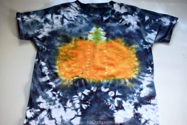 finished tie dye pumpkin shirt with a pumpkin in the middle and black tie dye edges