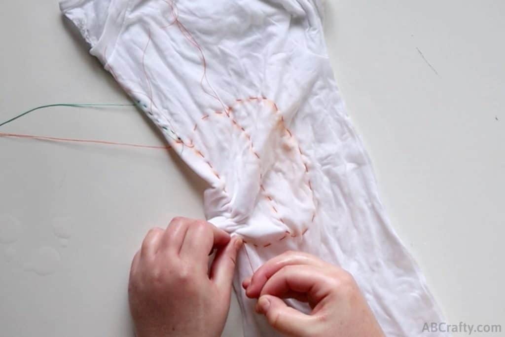 pulling on an orange thread to make folds in the shirt