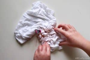 using hands to scrunch the edges of the shirt