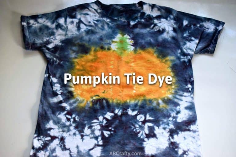 finished tie dye pumpkin shirt with a pumpkin in the middle and black tie dye edges with the title "pumpkin tie dye"