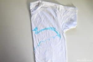 white cotton shirt folded in half with half of a bat drawn on it with blue washable marker
