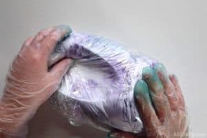 squishing the outside of a croc wrapped in plastic filled with shaving cream and dye