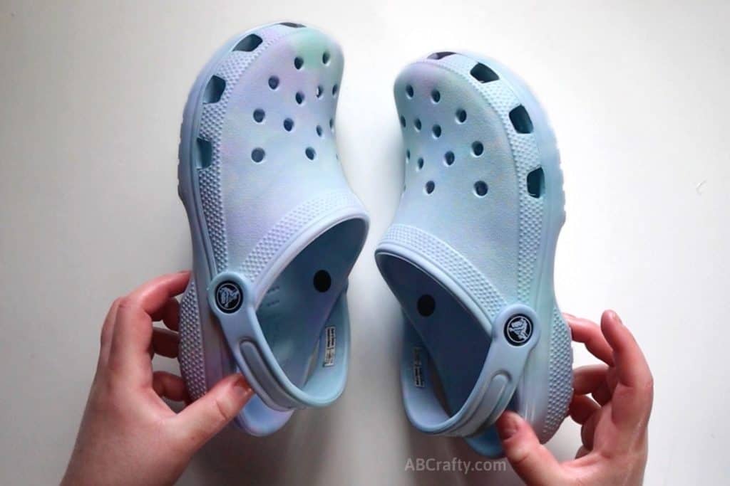 holding both finished DIY pastel tie dye crocs