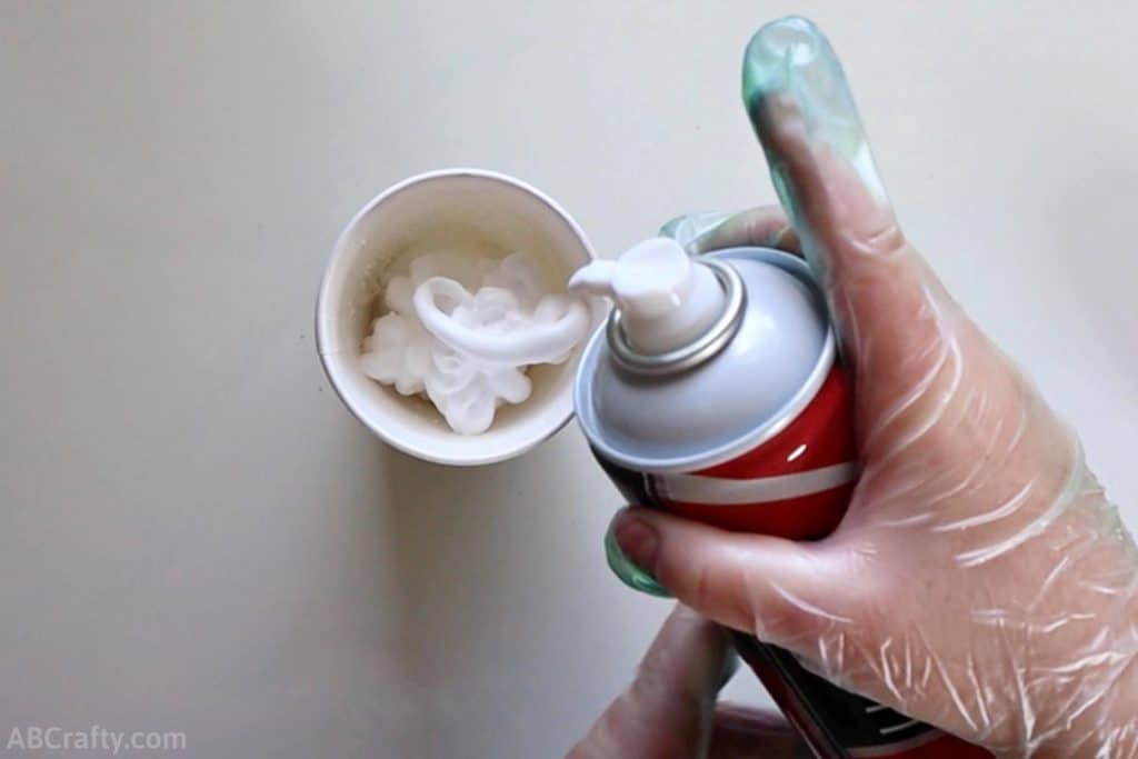spraying shaving cream into a paper cup