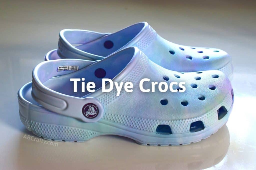 the finished DIY dyed crocs on the table with the title "tie dye crocs"