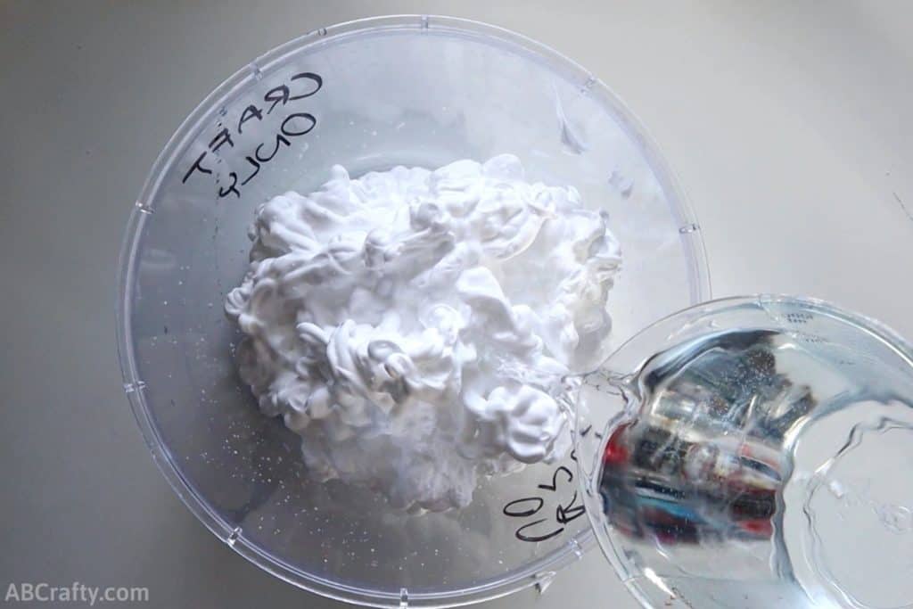 pouring water into a bowl with shaving cream