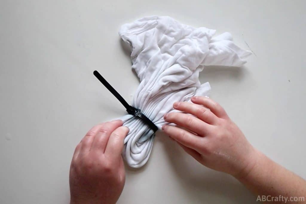 putting a zip tie on the folded shirt