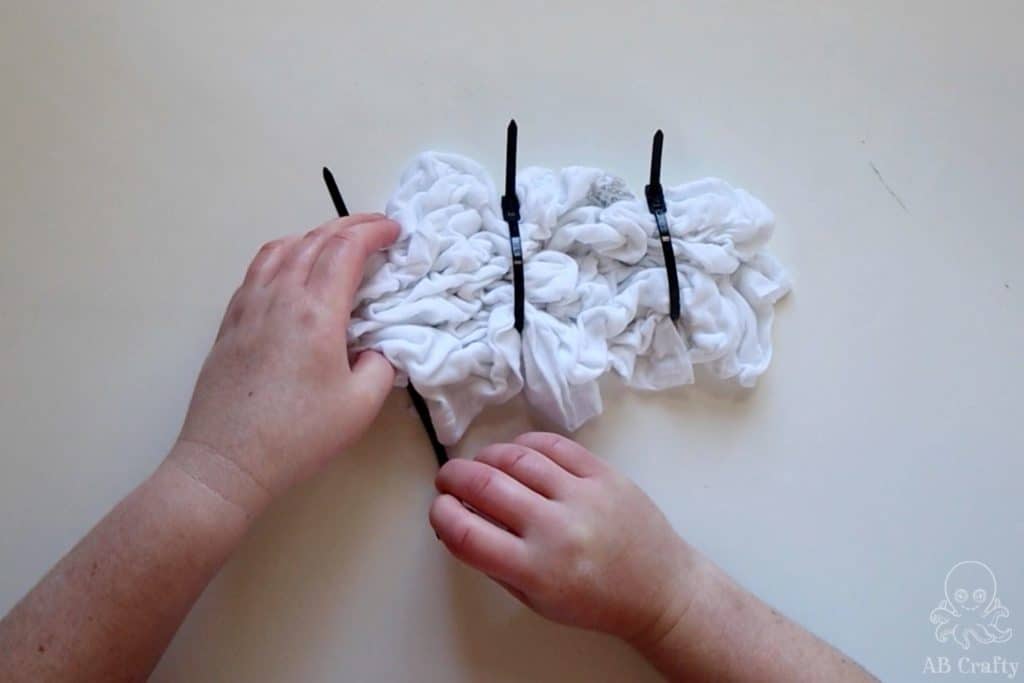 Wrapping a crumpled white cotton shirt with black zip ties