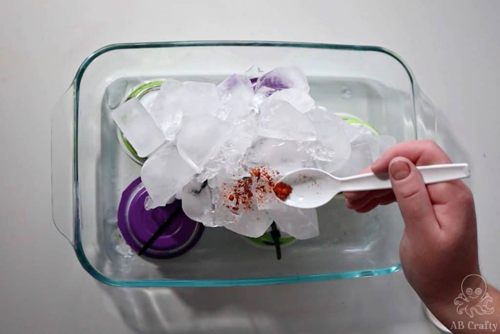 Sprinkling yellow powdered dye over ice on top of a shirt