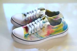 one side of finished tie dye shoes with rainbow tie dye pattern and white laces