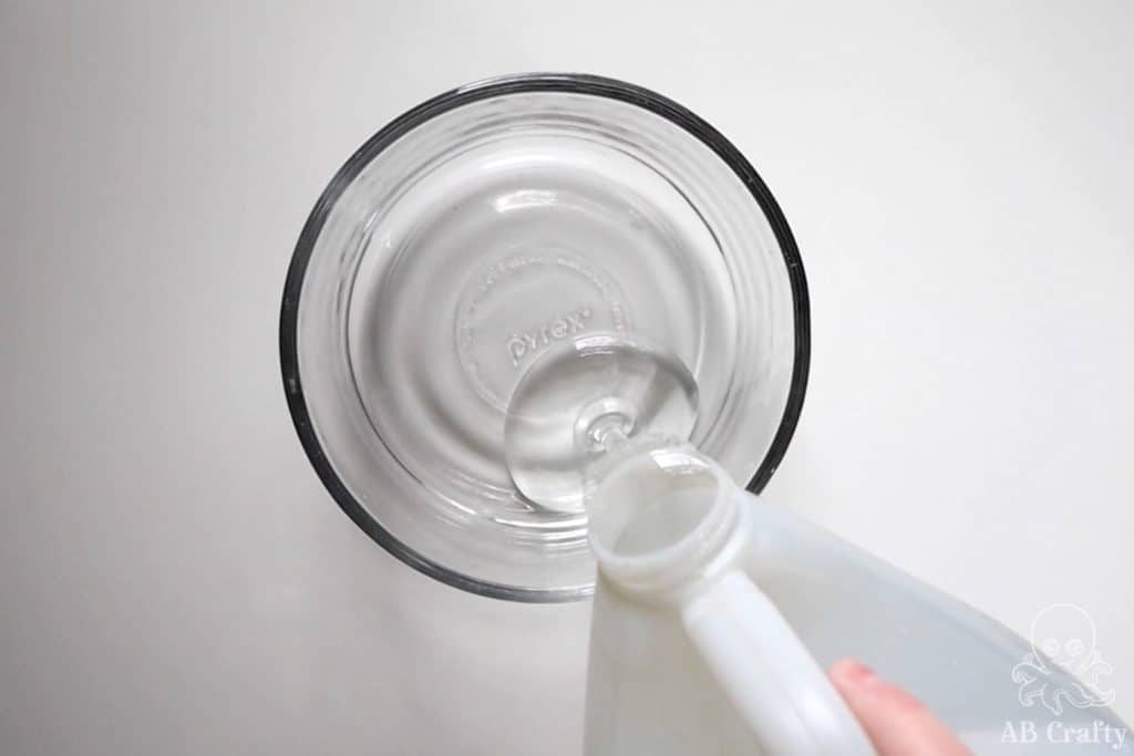 pouring clear glue into a glass bowl