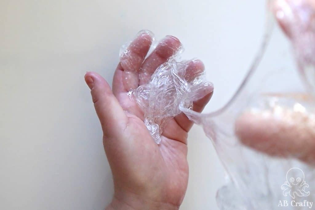 drizzling clear slime from one hand to another