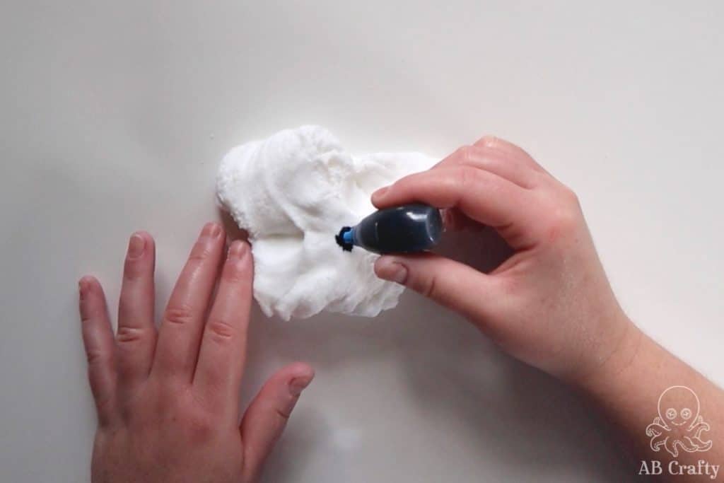 adding blue food coloring to white slime