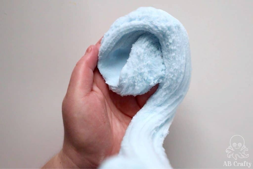 drizzling blue snow slime into a hand so it forms a spiral