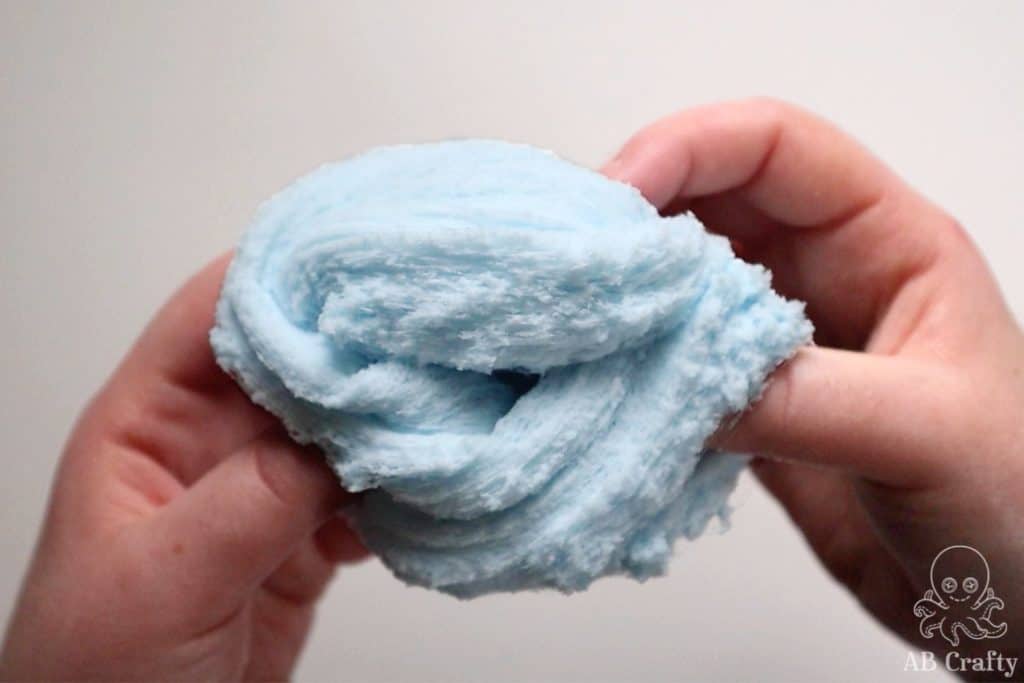 holding blue snow slime to show it fluffy