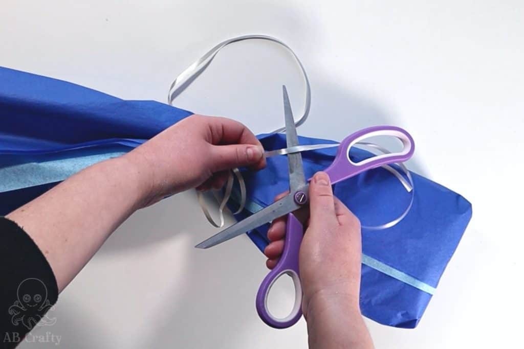 placing open scissors underneath the ribbon