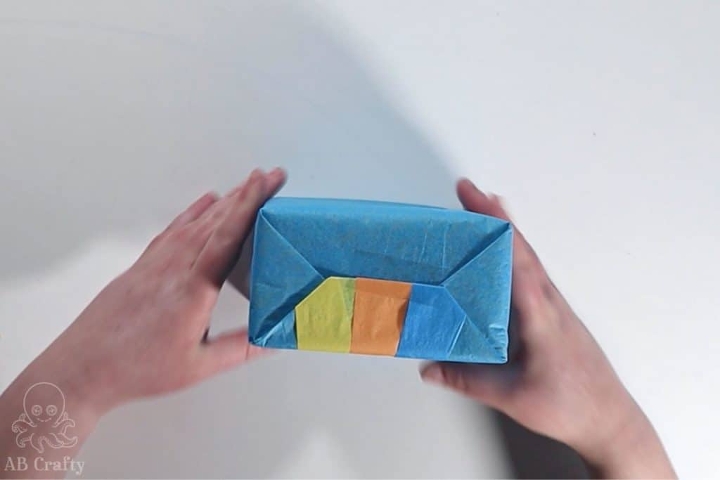 showing the side of the wrapped present with the three colors of tissue paper