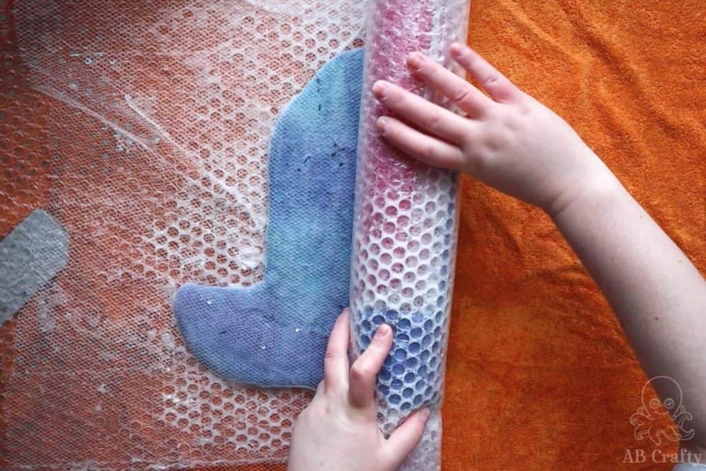 rolling the felting project around a pool noodle and bubble wrap