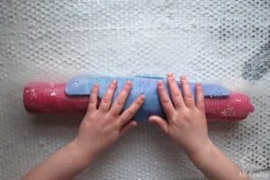 rolling the felting project around a pool noddle and mesh fabric
