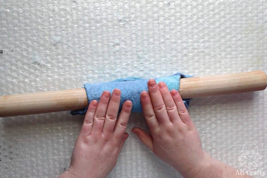 rolling the felted wool around a wooden dowel