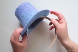 holding the wet felted mini top hat on a headband