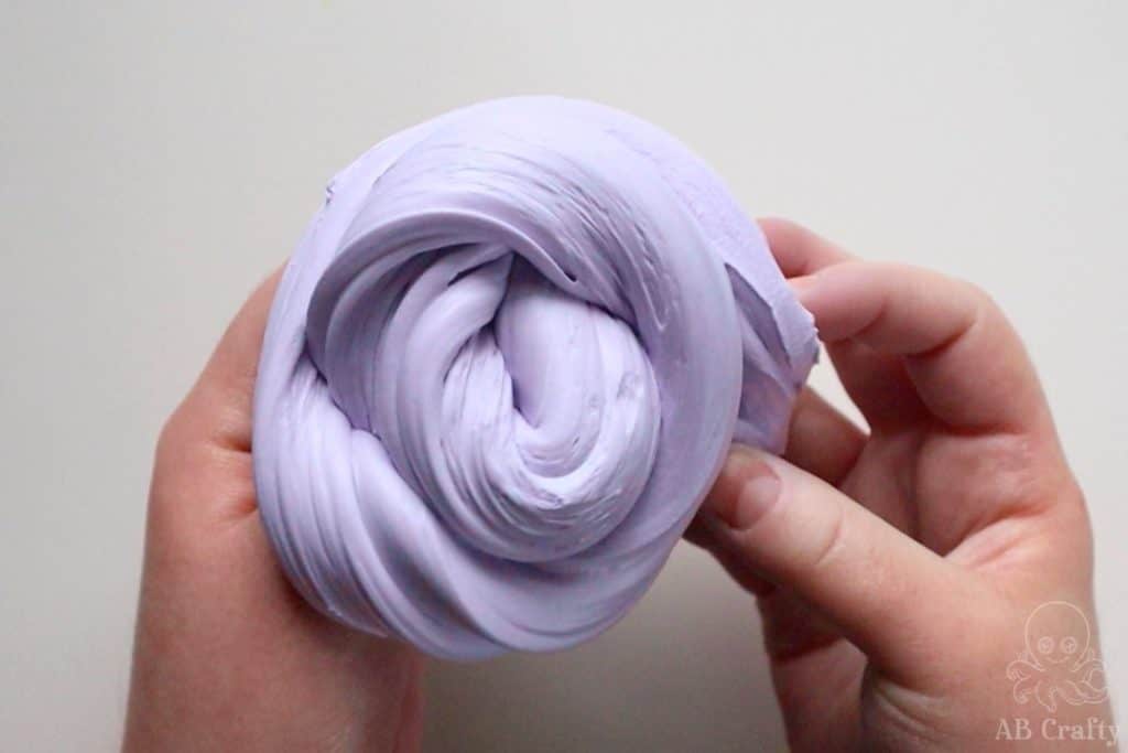 holding the purple fluffy slime shaped into a coil