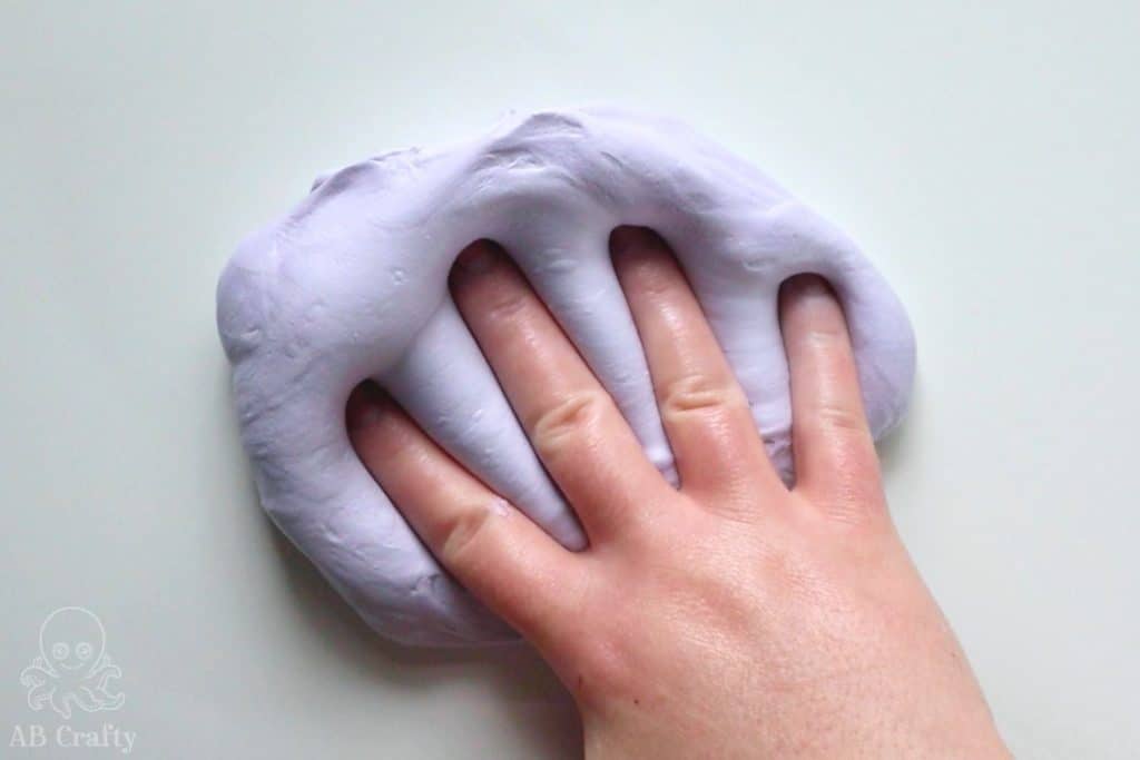 pushing a hand into the purple fluffy slime