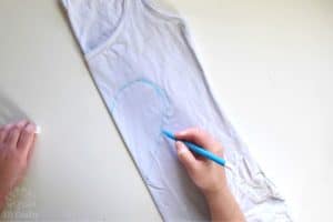 drawing a heart with a washable marker onto a white cotton tank top that's been folded in half