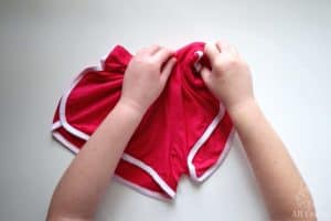 twisting the top corner of pink shorts with white seams